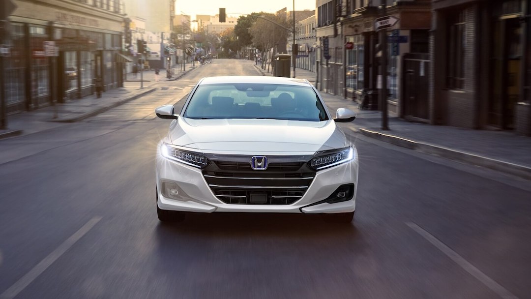vue avant de la Honda Accord Hybride 2022 blanc roulant sur un boulevard en ville