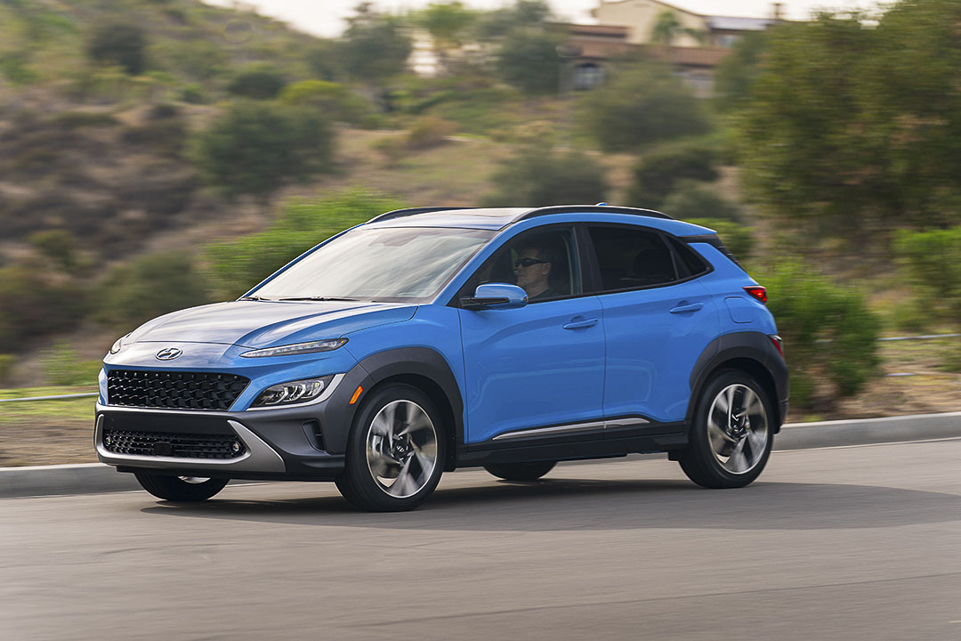 vue 3/4 avant du Hyundai Kona 2022 bleu roulant sur une route