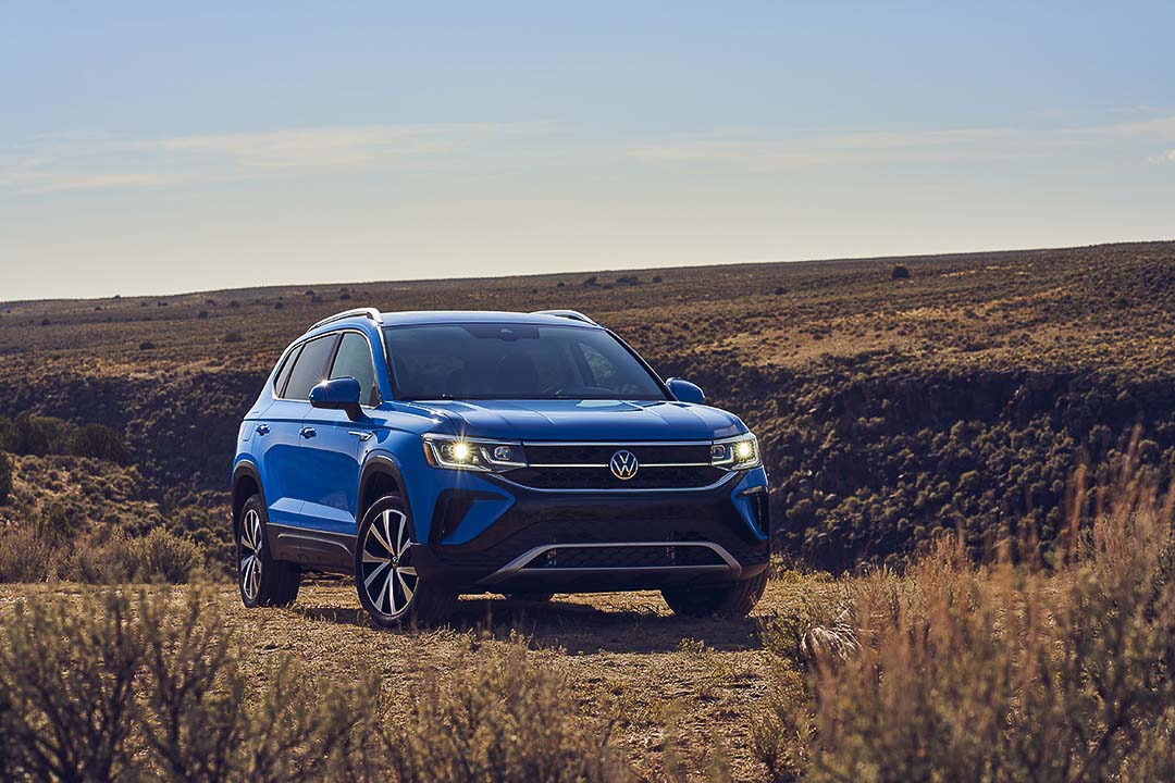 vue 3/4 avant du sous-compact Volkswagen Taos garé dans un champs en campagne