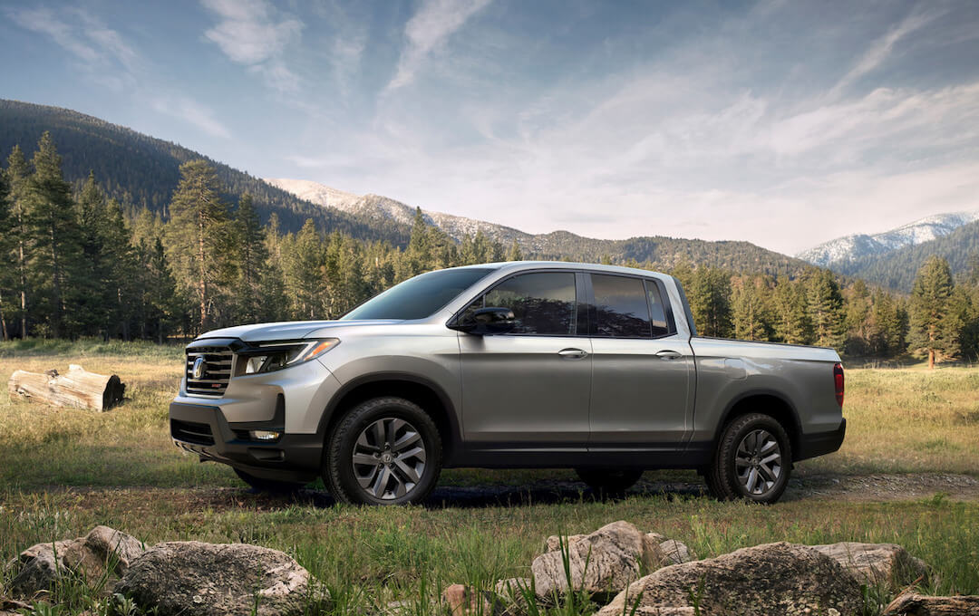 Vue latérale du Honda Ridgeline 2023 garé en nature.